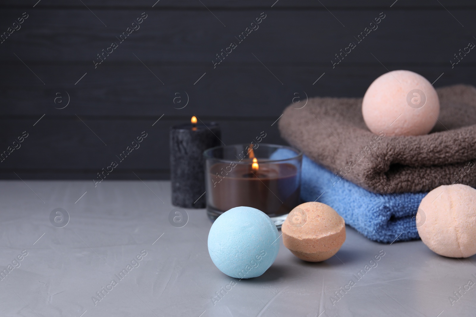 Photo of Beautiful composition with aromatic bath bombs on light grey table, space for text