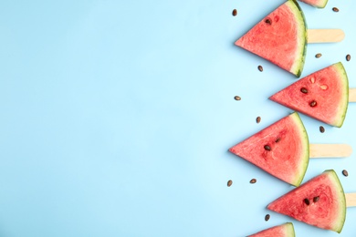 Photo of Slices of ripe watermelon on light blue background, flat lay. Space for text