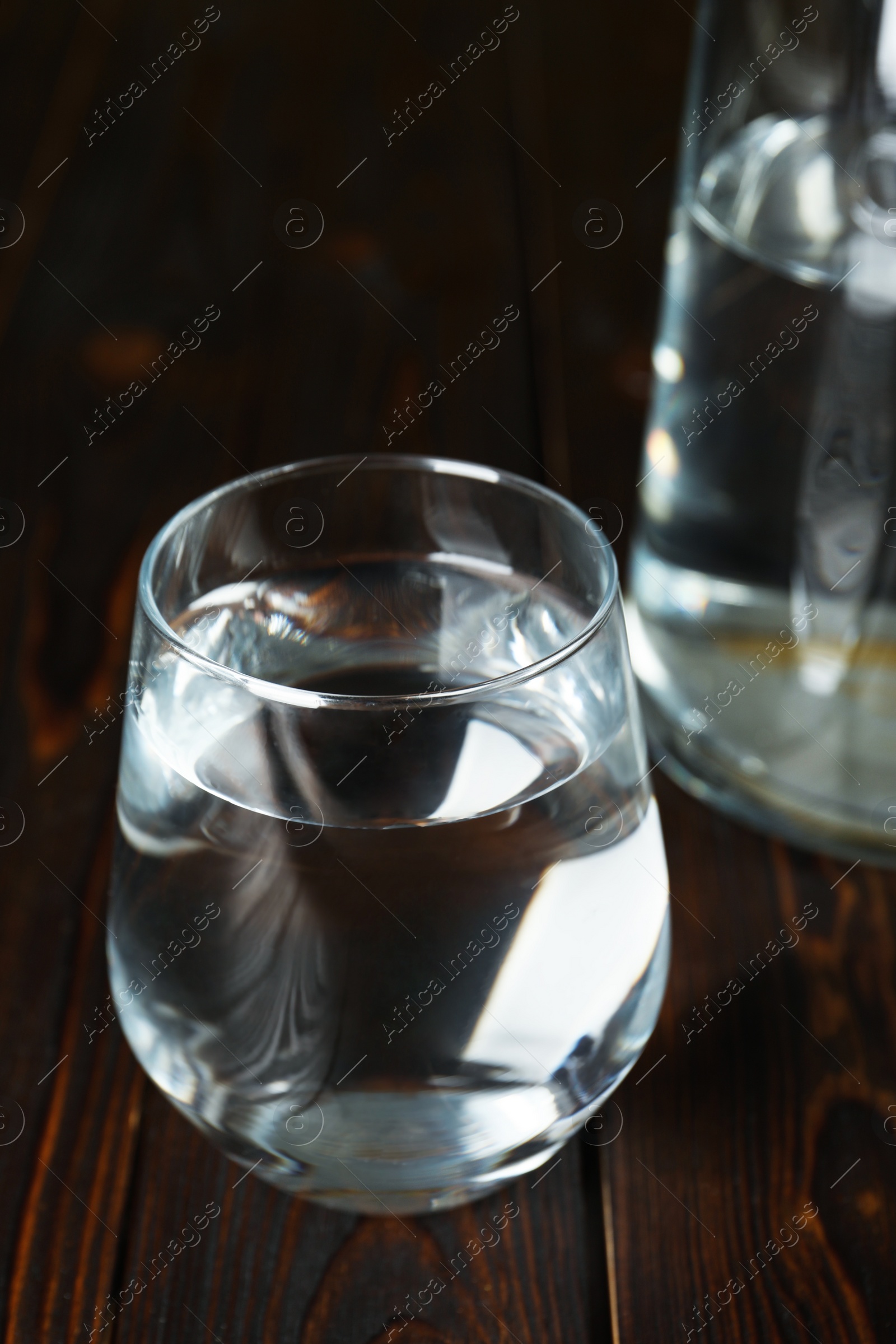 Photo of Glass of water on wooden table, closeup. Refreshing drink