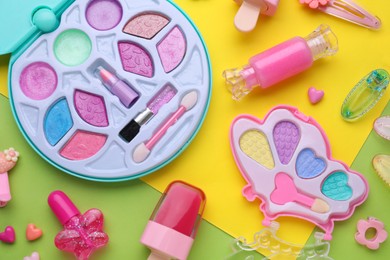 Photo of Eye shadow palette and other decorative cosmetics for kids on color background, flat lay