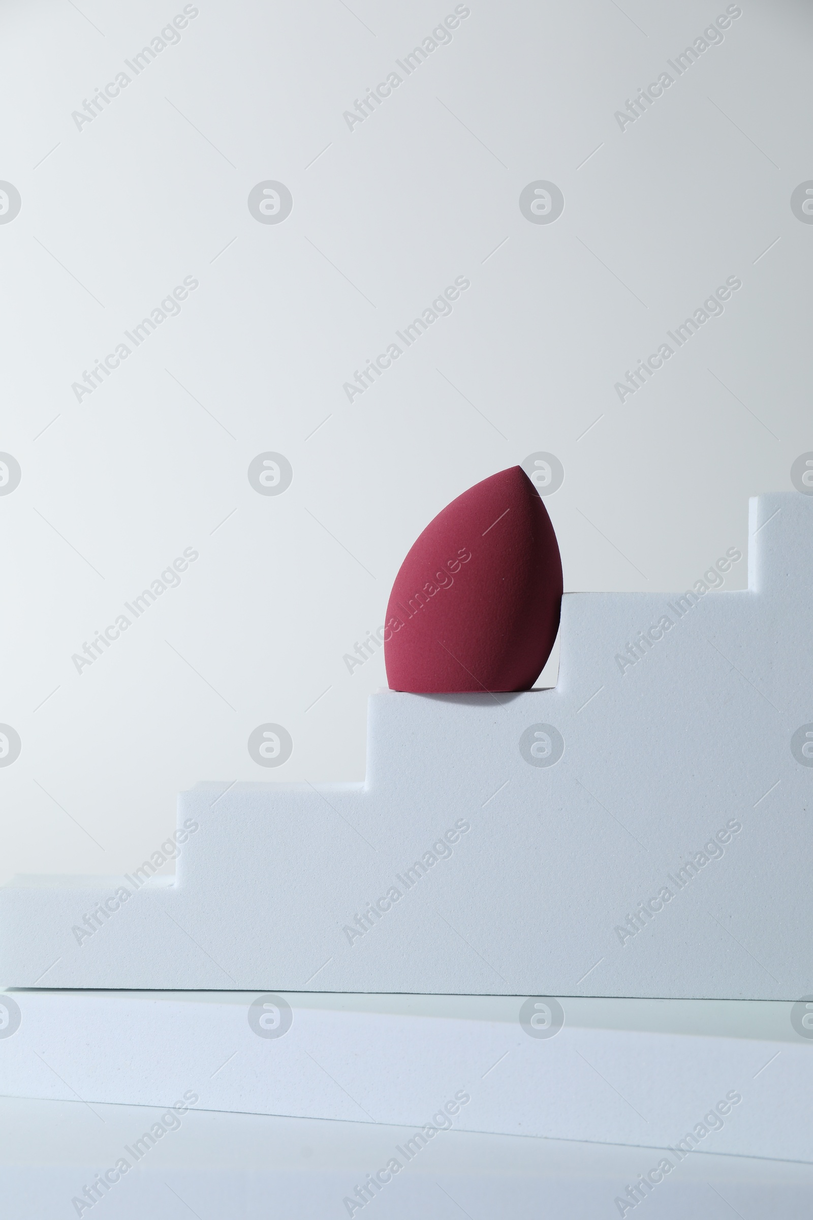 Photo of Stylish presentation of makeup sponge on white background