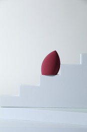 Stylish presentation of makeup sponge on white background