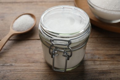 Photo of Granulated sugar on wooden table, closeup view