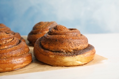 Parchment with freshly baked cinnamon rolls on table, closeup