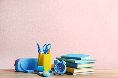 Photo of Different school stationery on wooden table against pink background. Space for text