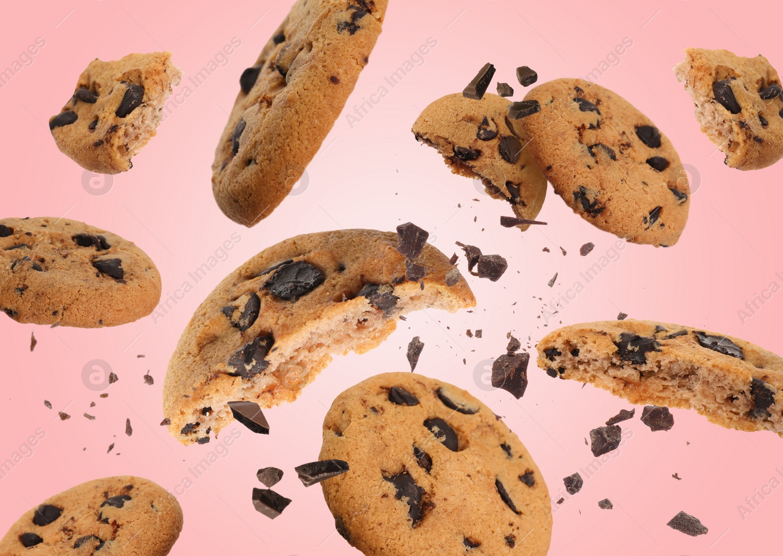 Image of Tasty chocolate chip cookies falling on pink background