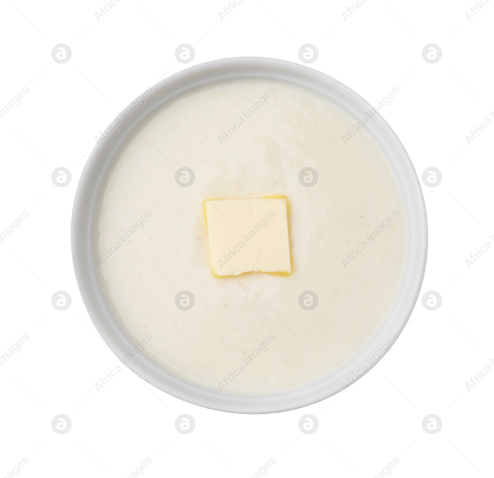 Photo of Bowl of delicious semolina pudding with butter isolated on white, top view