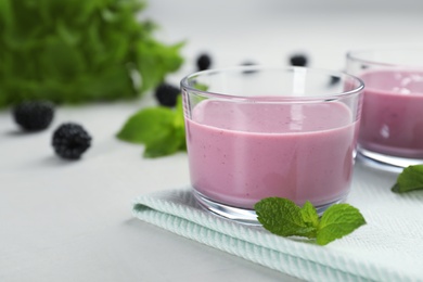 Photo of Glasses with tasty blackberry yogurt smoothies on table