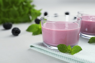 Glasses with tasty blackberry yogurt smoothies on table