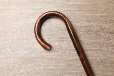 Photo of Elegant walking cane on wooden table, top view