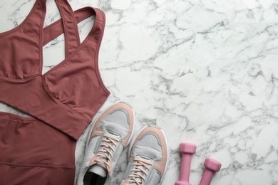 Photo of Flat lay composition with sportswear and equipment on white marble table, space for text. Gym workout