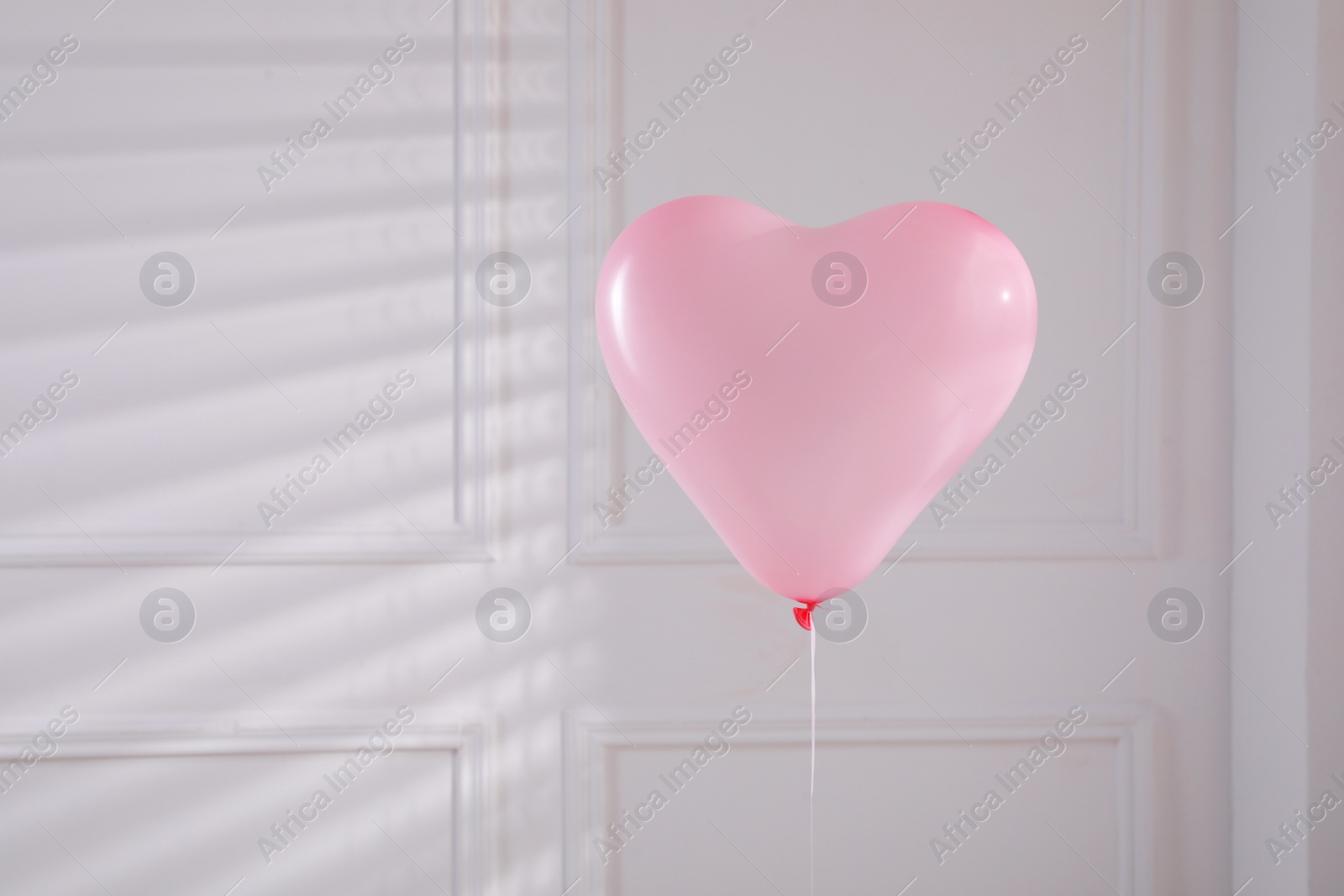 Photo of Festive heart shaped balloon in light room