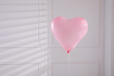 Festive heart shaped balloon in light room