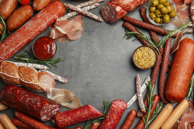Photo of Frame made with sausages on grey table, flat lay. Space for text