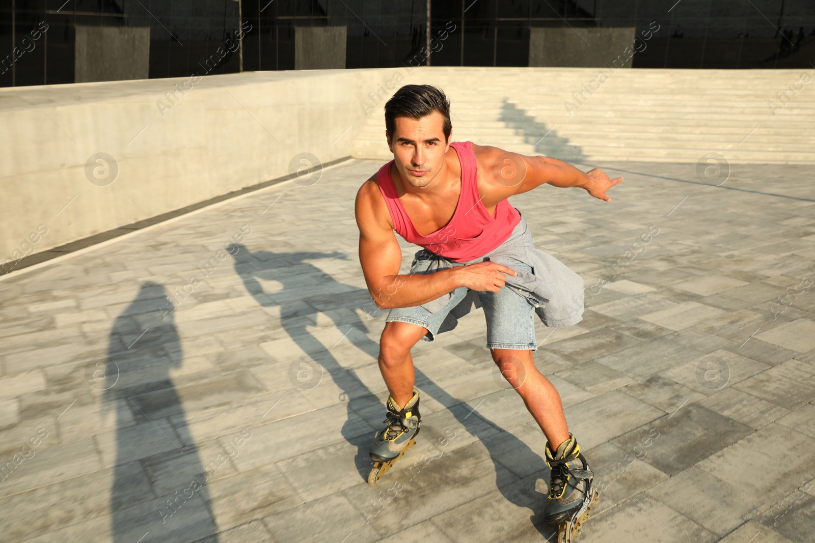 Photo of Handsome young man roller skating on city street, space for text