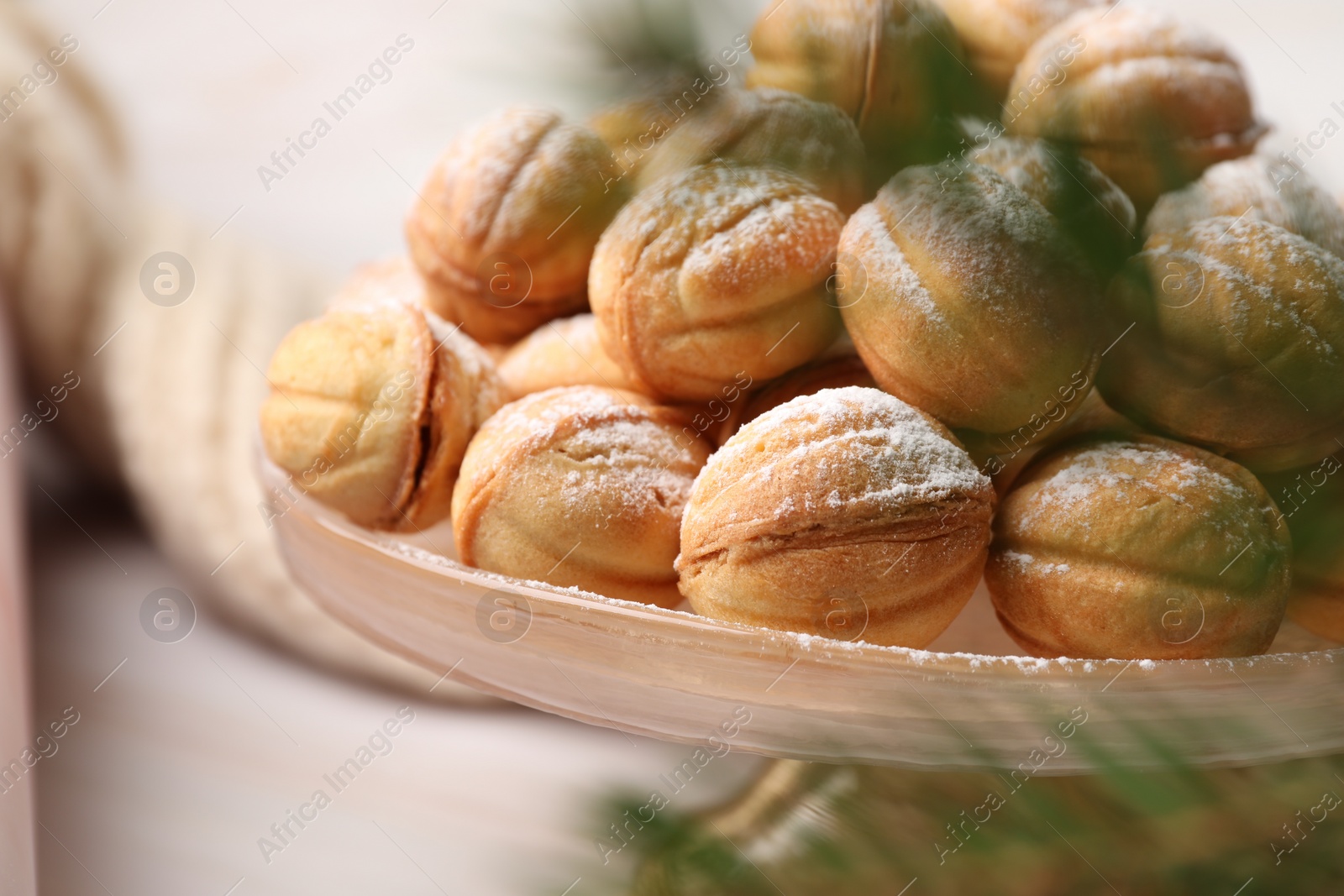 Photo of Delicious nut shaped cookies and fir tree branches on table, closeup