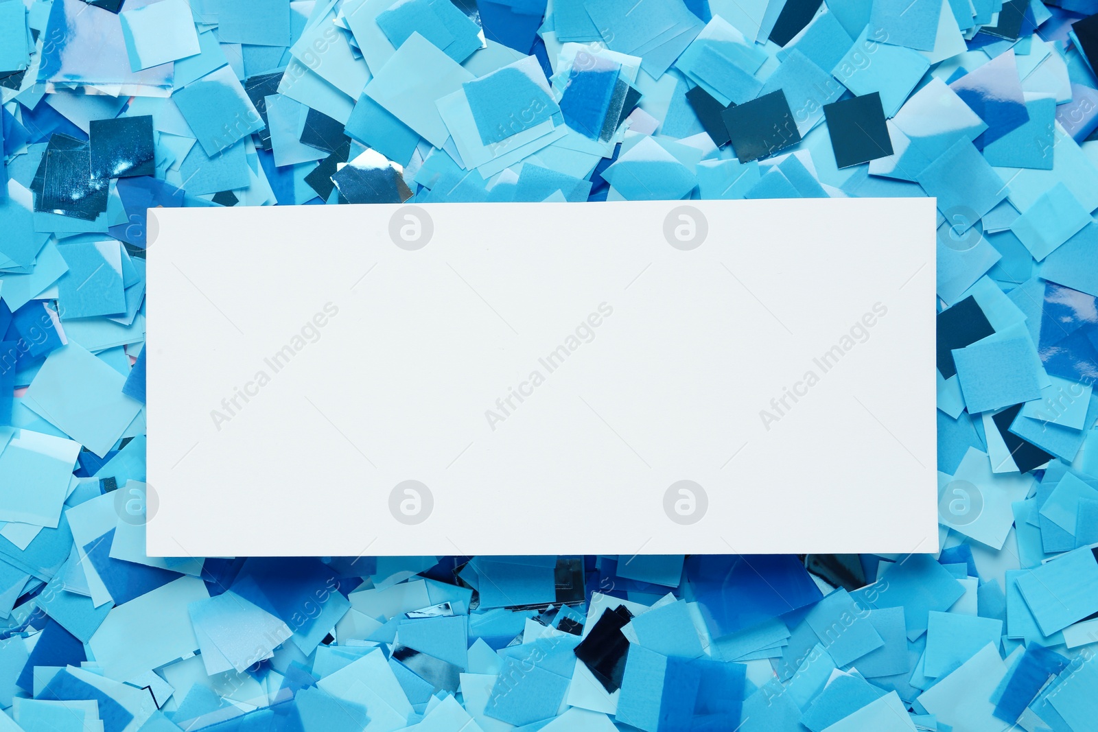 Photo of Card on light blue confetti, top view. Space for text