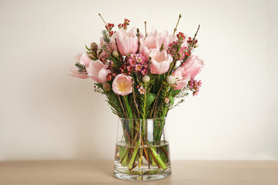 Photo of Beautiful bouquet with spring pink tulips on table