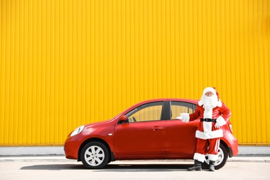 Authentic Santa Claus near red car, outdoors