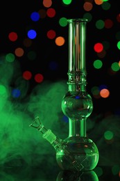 Photo of Glass bong with smoke against blurred lights, toned in green. Smoking device