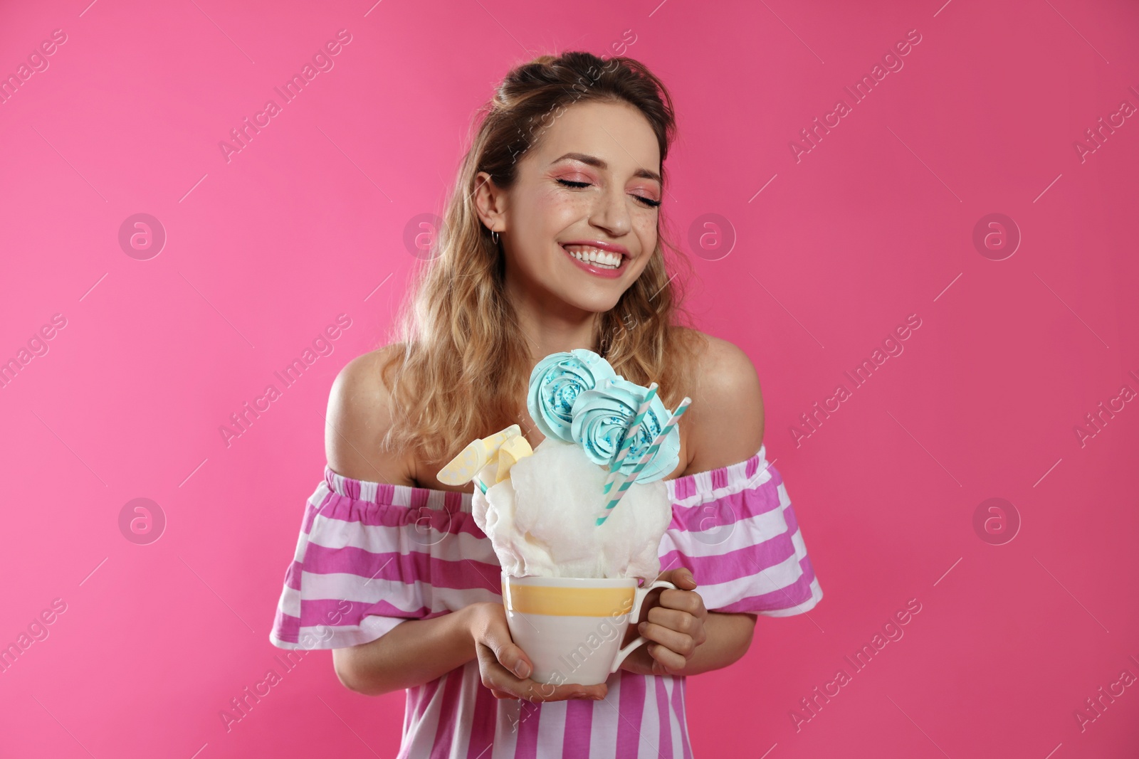 Photo of Portrait of young woman holding cotton candy dessert on color background