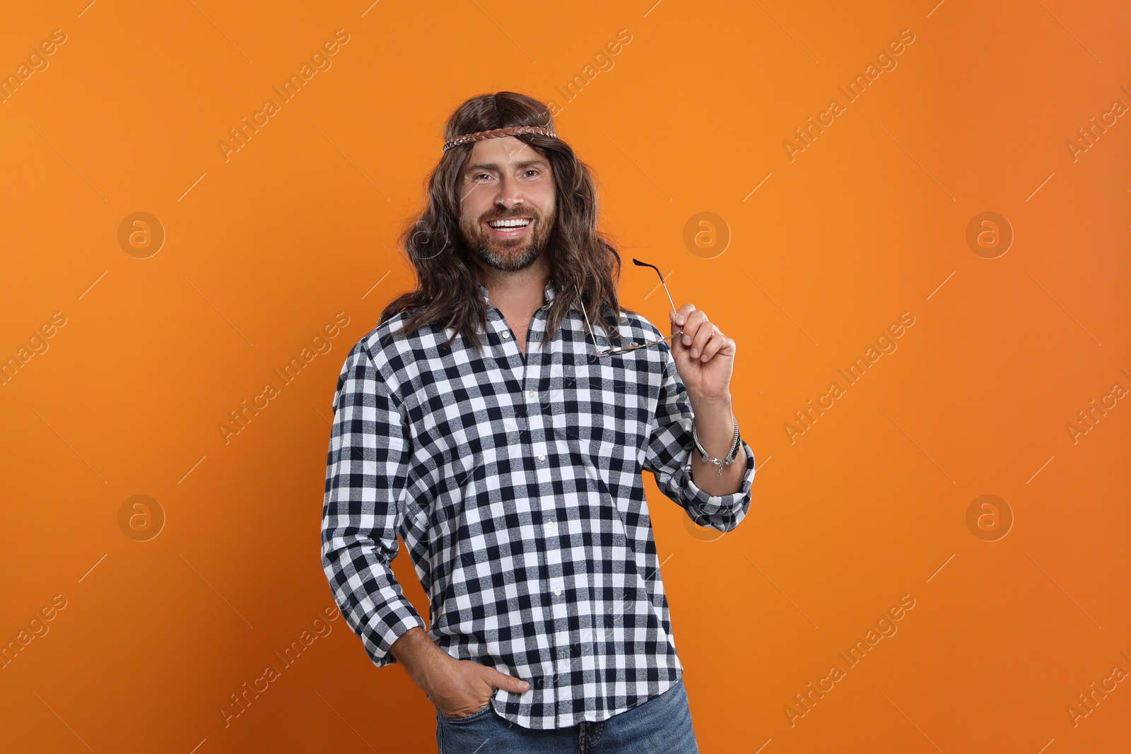 Photo of Hippie man with sunglasses on orange background