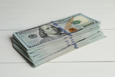 Photo of Money exchange. Stack of dollar banknotes on white wooden background