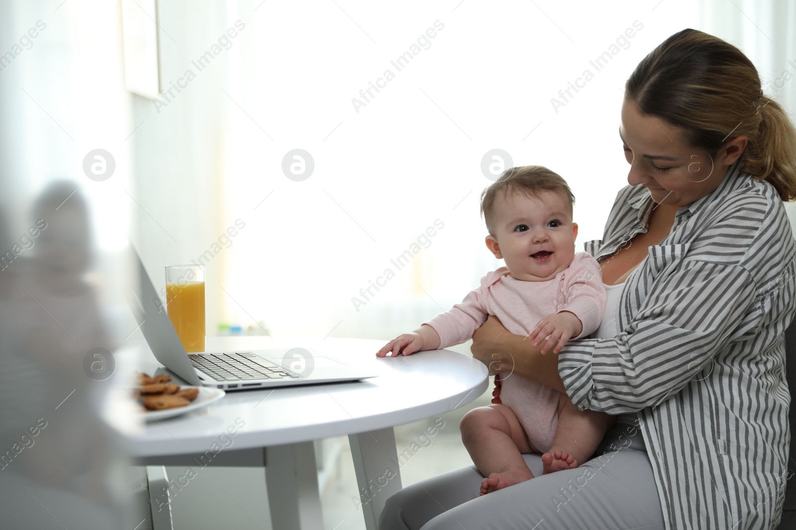 Photo of Young woman with her cute baby at home