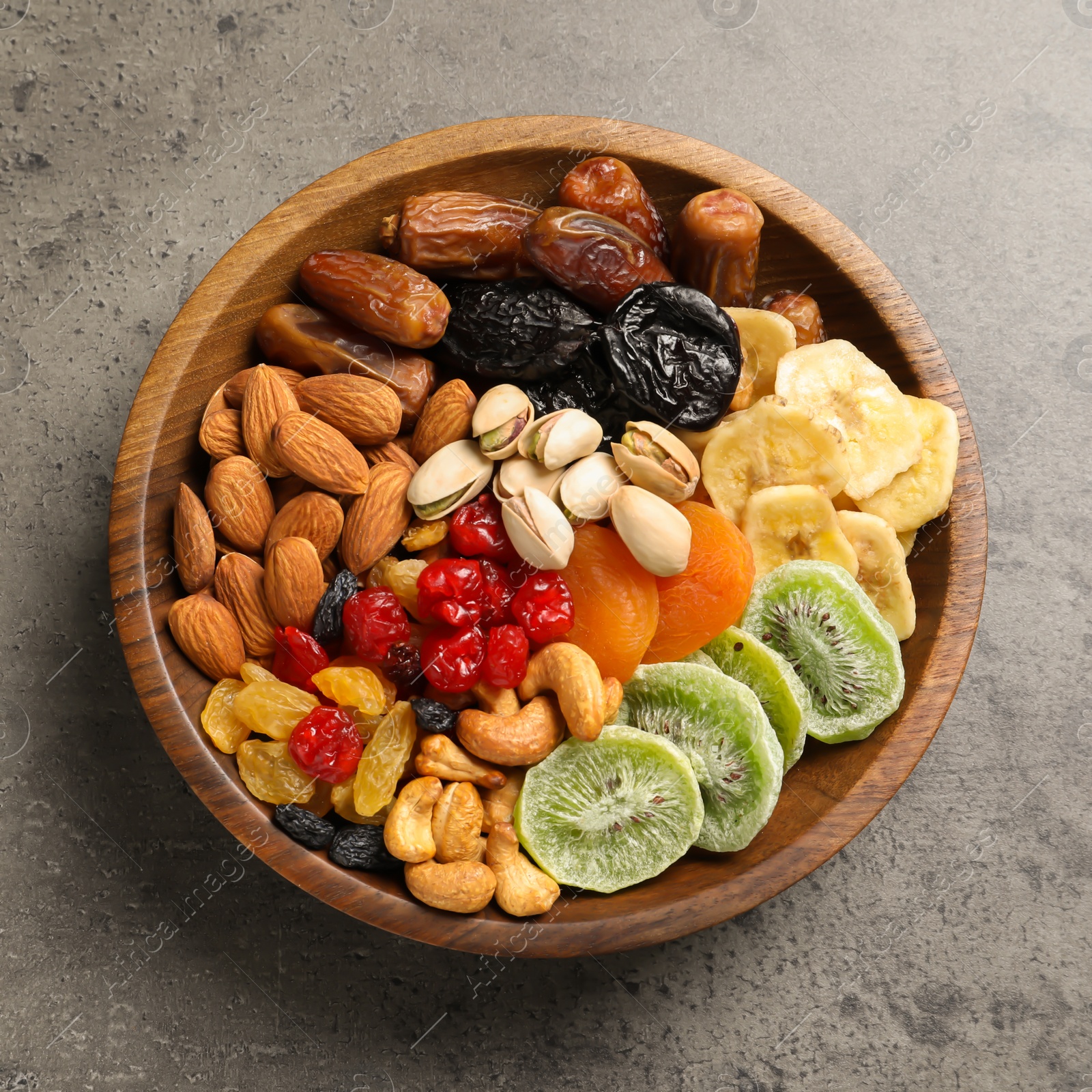 Photo of Plate with different dried fruits and nuts on table, top view