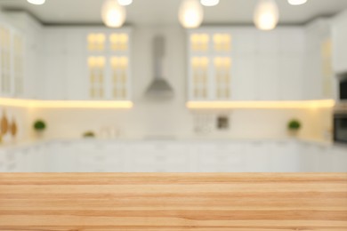 Empty wooden table and blurred view of stylish kitchen interior. Mockup for design