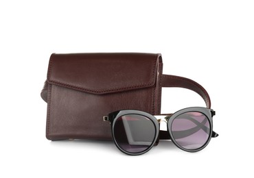 Photo of Brown women's leather flap bag and sunglasses on white background