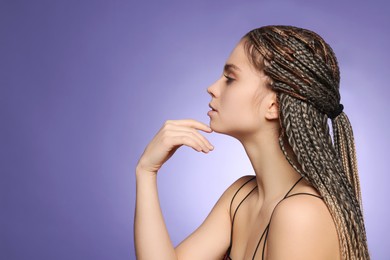 Beautiful woman with long african braids on purple background, space for text