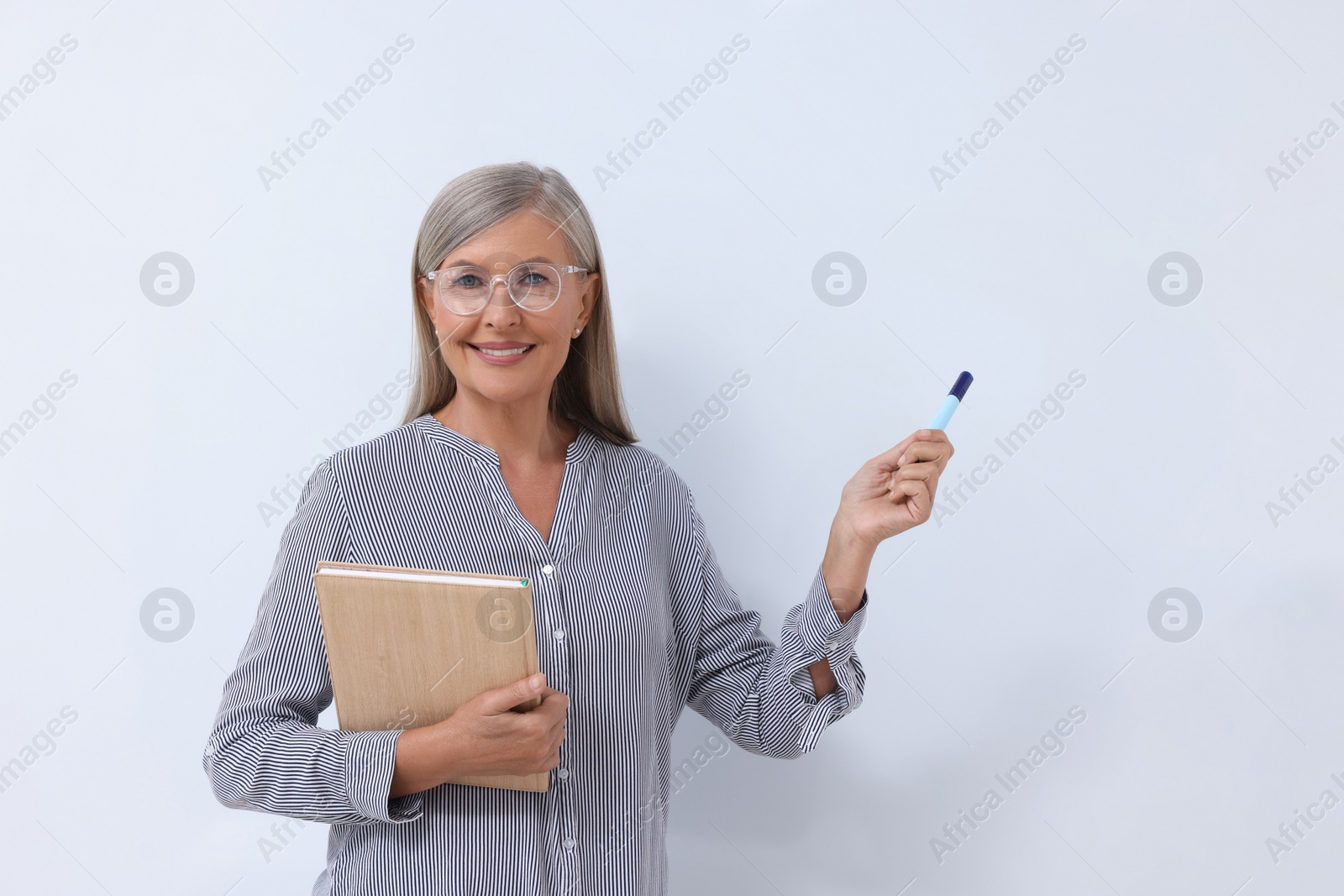 Photo of Professor with notebook and marker giving lecture near whiteboard