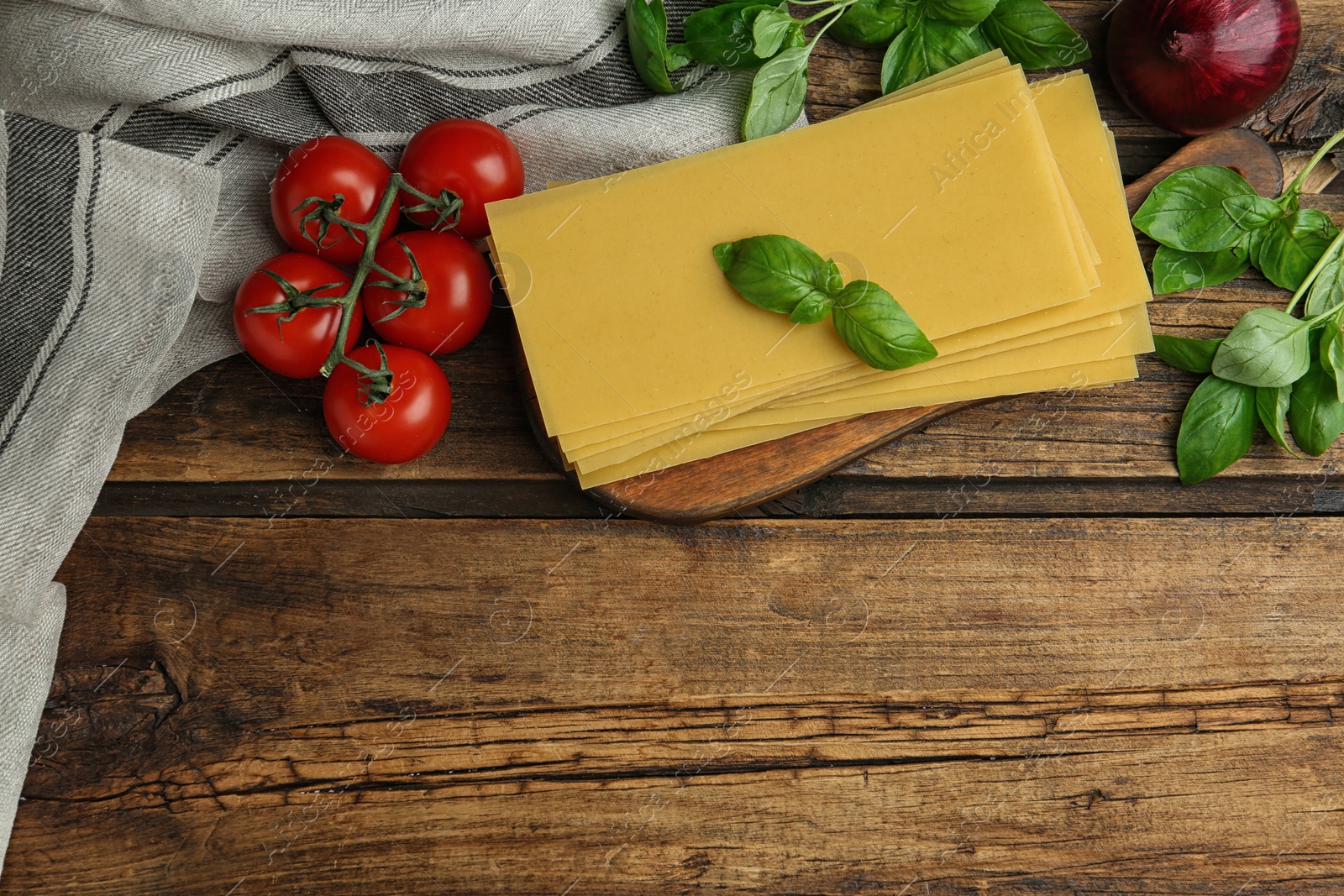 Photo of Flat lay composition with uncooked lasagna sheets on wooden table, space for text