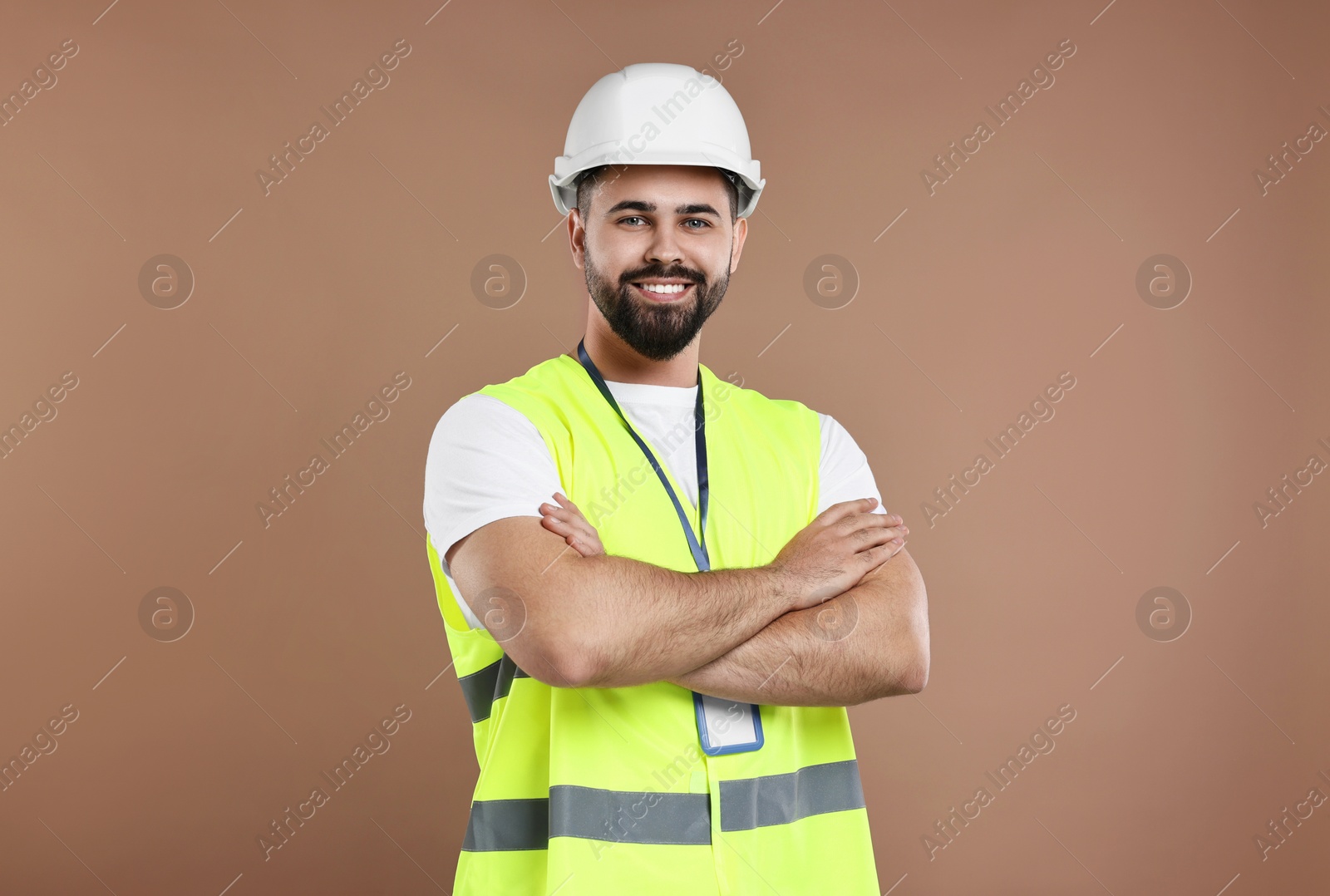 Photo of Engineer with hard hat and badge on brown background
