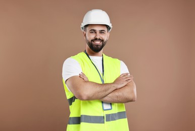 Engineer with hard hat and badge on brown background