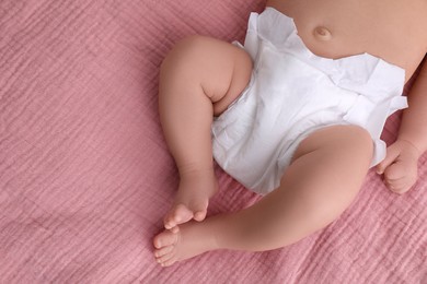 Photo of Little baby in diaper on bed, closeup