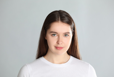 Portrait of young woman on light background