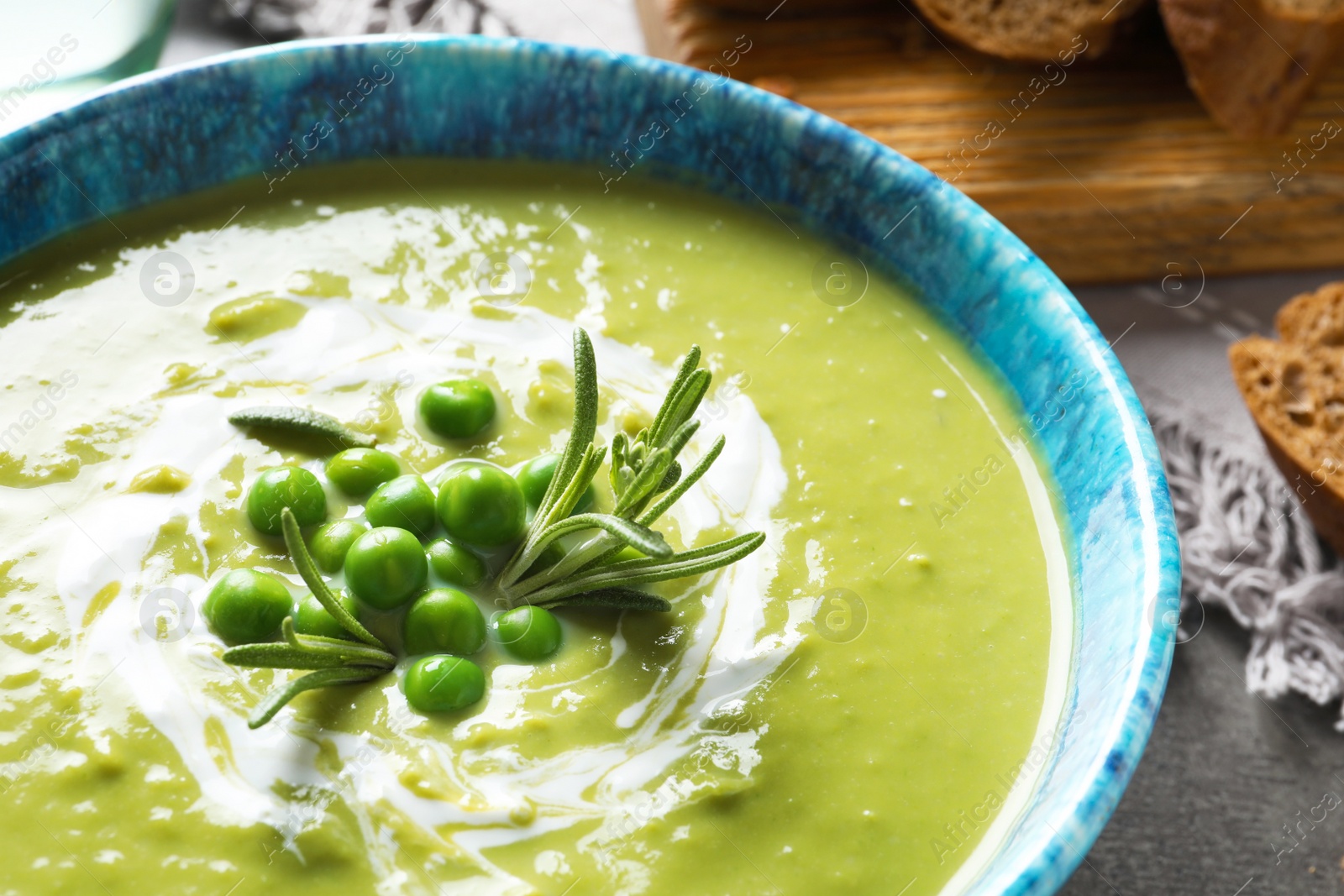 Photo of Fresh vegetable detox soup made of green peas in dish on table, closeup