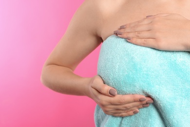 Photo of Woman checking her breast on color background, closeup