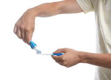 Photo of Man applying toothpaste on brush against white background, closeup