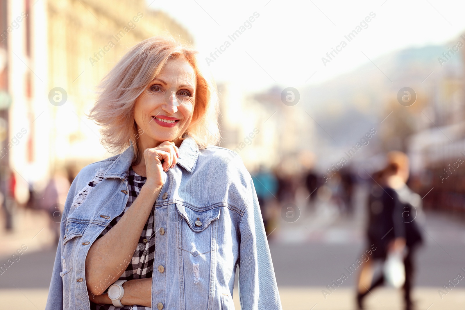 Photo of Portrait of happy mature woman on city street