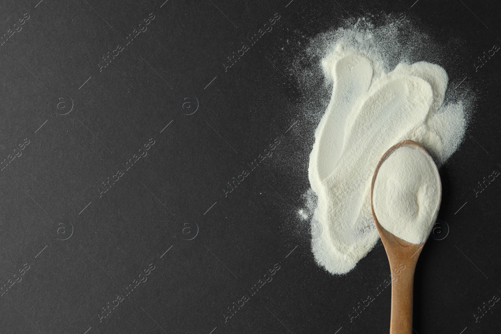 Photo of Spoon of agar-agar powder on black background, flat lay. Space for text