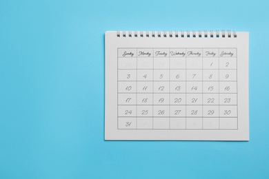 Photo of Paper calendar on light blue background, top view. Space for text