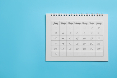 Paper calendar on light blue background, top view. Space for text