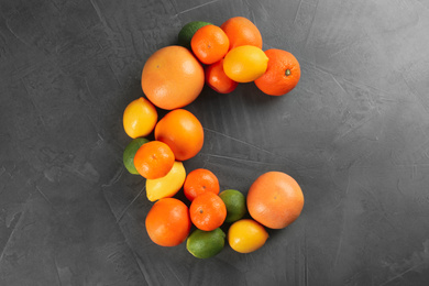 Photo of Letter C made with citrus fruits on grey table as vitamin representation, flat lay