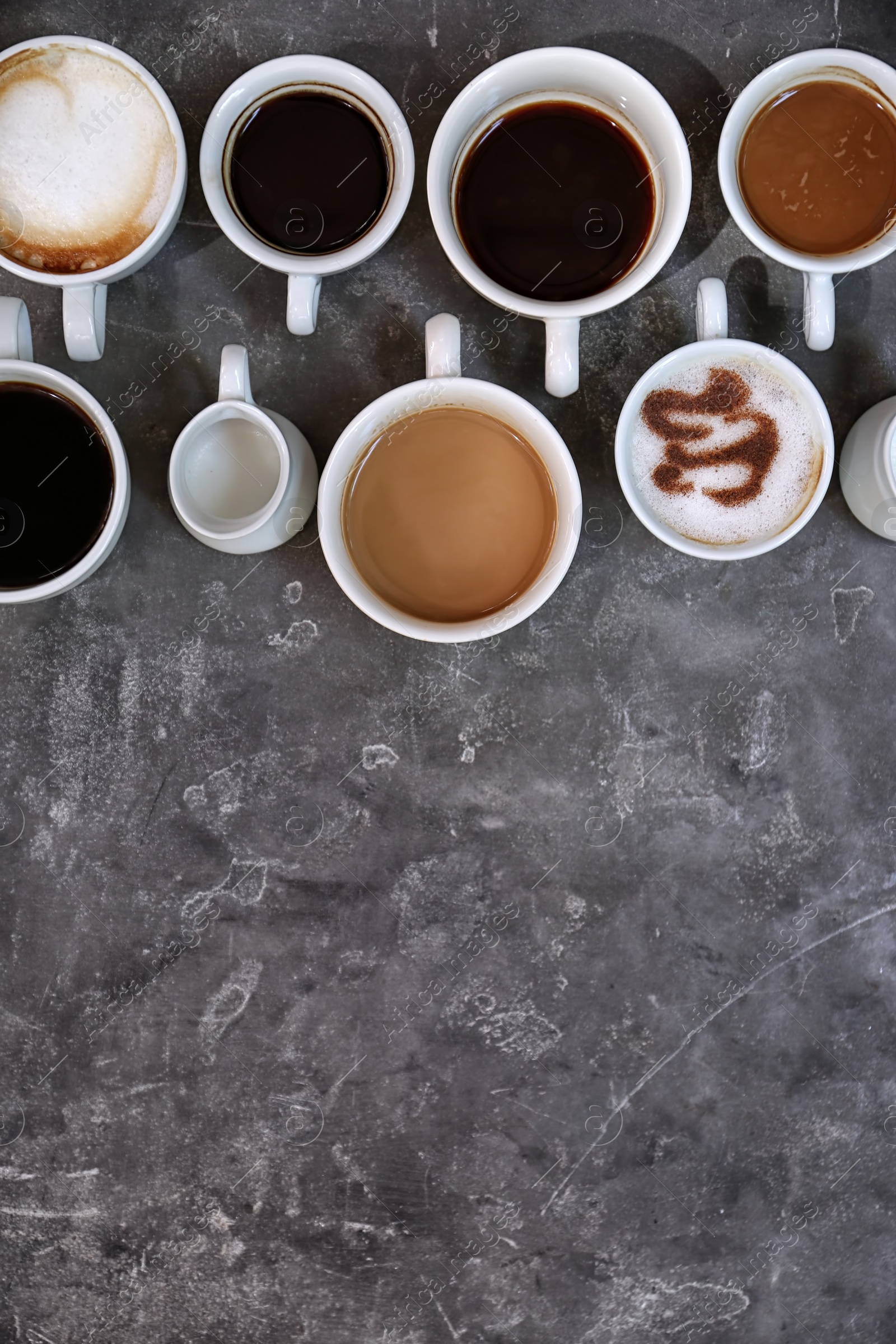 Photo of Cups of fresh aromatic coffee on grey background, top view