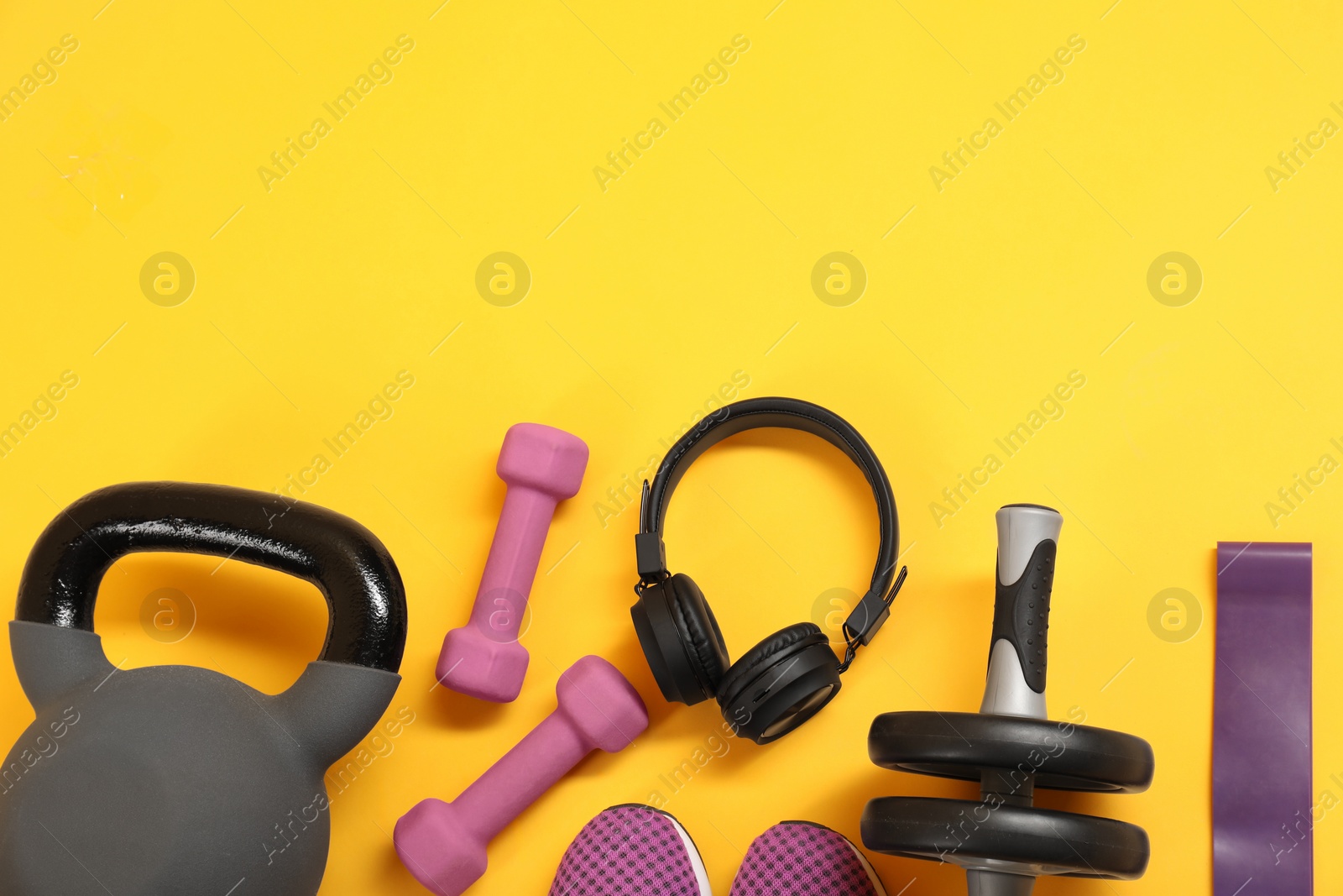 Photo of Different sports equipment on yellow background, flat lay. Space for text