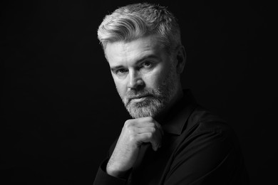 Portrait of handsome man on dark background. Black and white effect