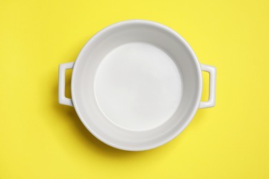 White empty pot on yellow background, top view